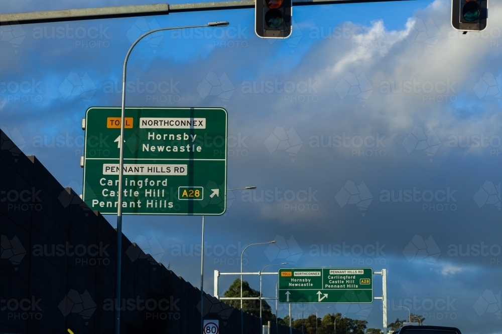 Green signs above road with arrows and directions to pennant hills A28 - Australian Stock Image