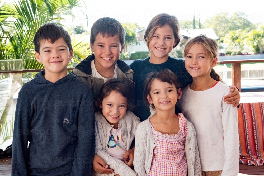 Group of children standing close together. - Australian Stock Image