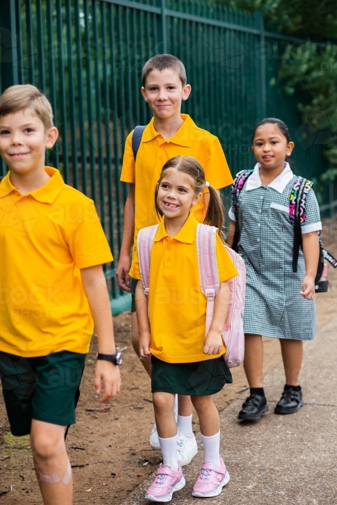 Group of happy kids walking to school together - Australian Stock Image