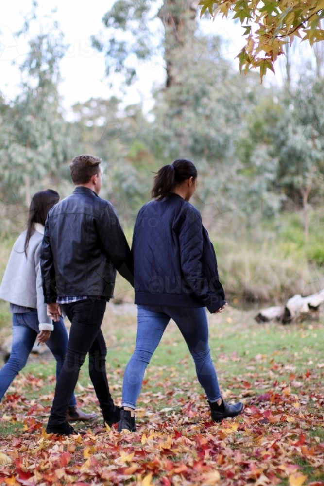 Group of young people walking in a rural environment in autumn - Australian Stock Image