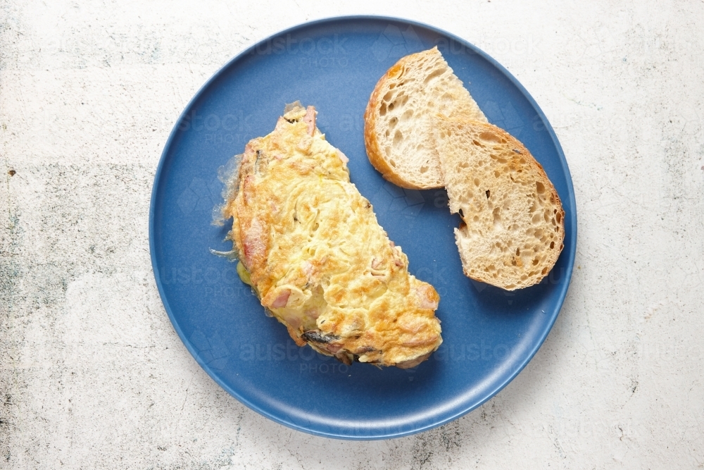 Ham cheese and mushroom omelette served in a blue plate. - Australian Stock Image