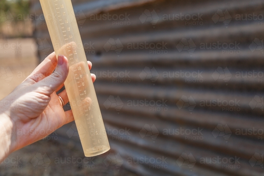 Hand holding empty rain gauge drought concept - Australian Stock Image