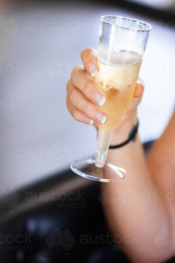 Hand holding glass of champagne - Australian Stock Image