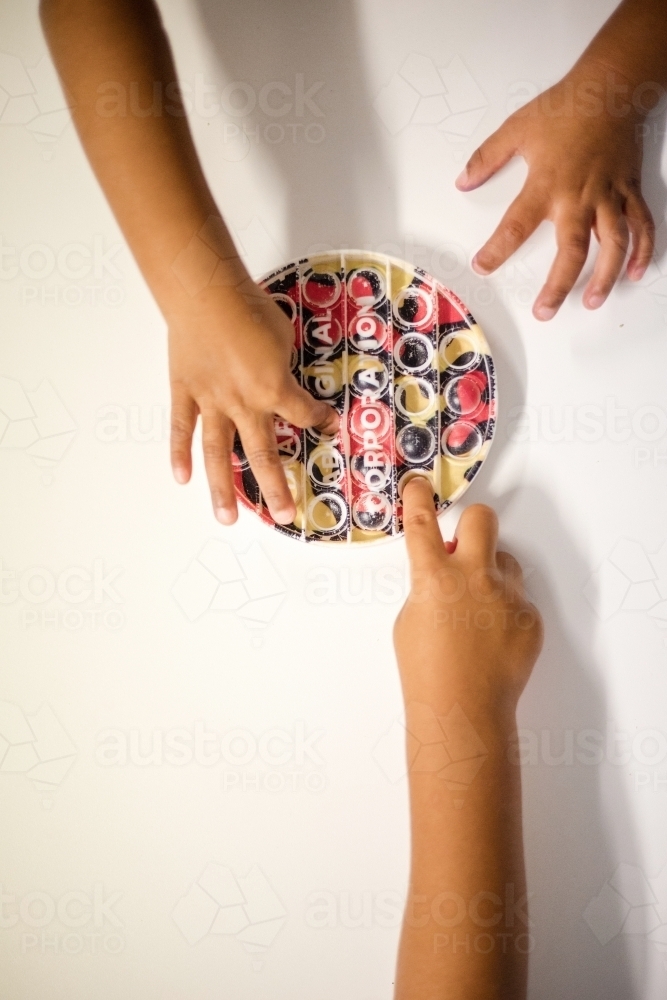 Hands of young Aboriginal girl playing with toy - Australian Stock Image