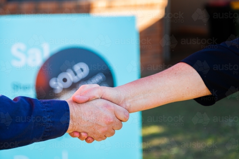 Handshake in agreement and congratulations on house purchase and sale - Australian Stock Image