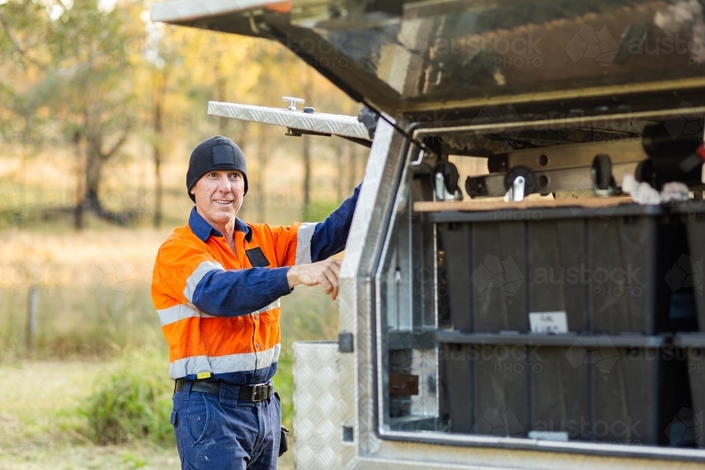 Handyman getting tools from back of tradie ute - Australian Stock Image