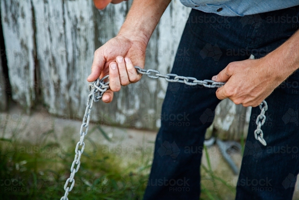 Hans hands holding chain - Australian Stock Image