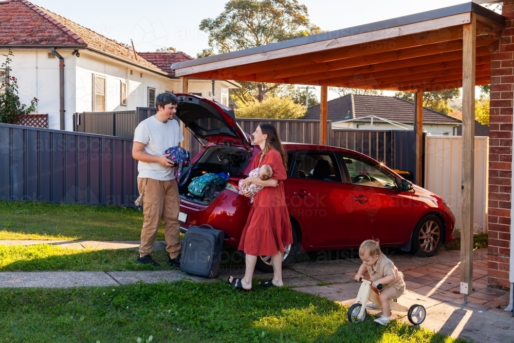 happy Aussie family packing car boot with luggage for weekend holiday trip - Australian Stock Image