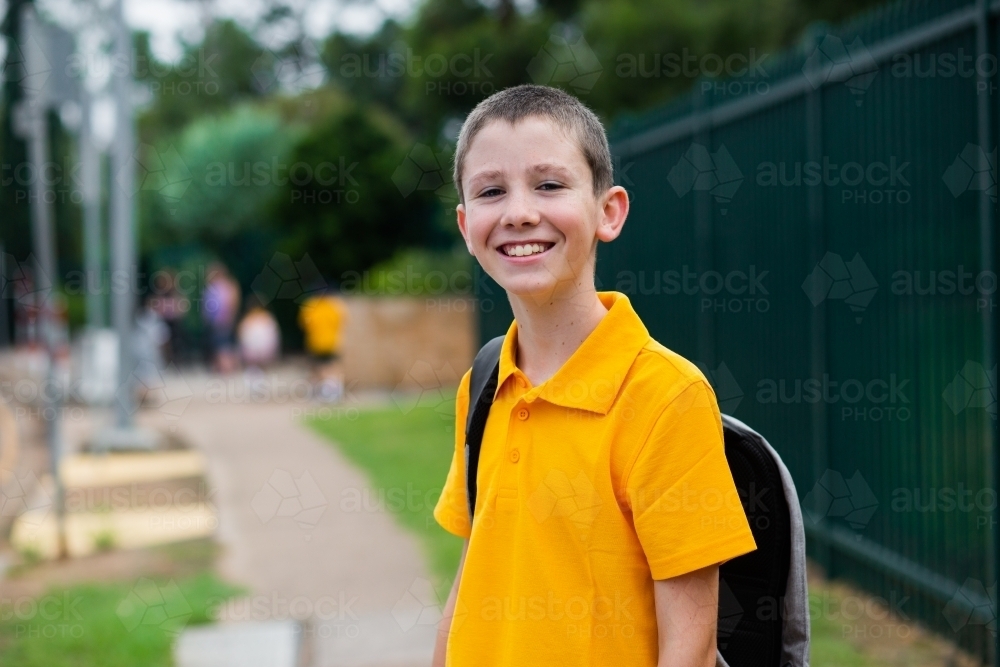 Happy Aussie public school boy with bag ready to go back to school - Australian Stock Image