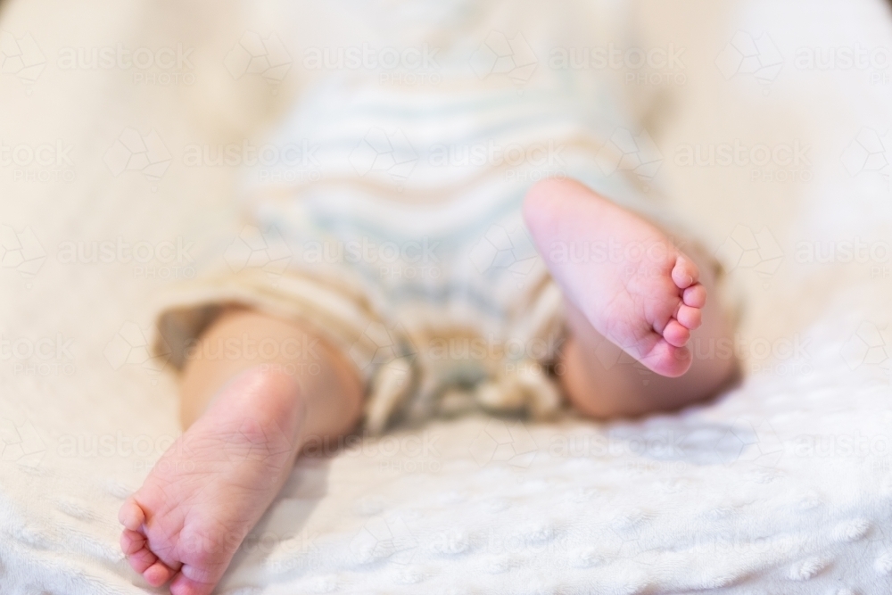 Happy baby feet kicking during tummy time on change table - Australian Stock Image