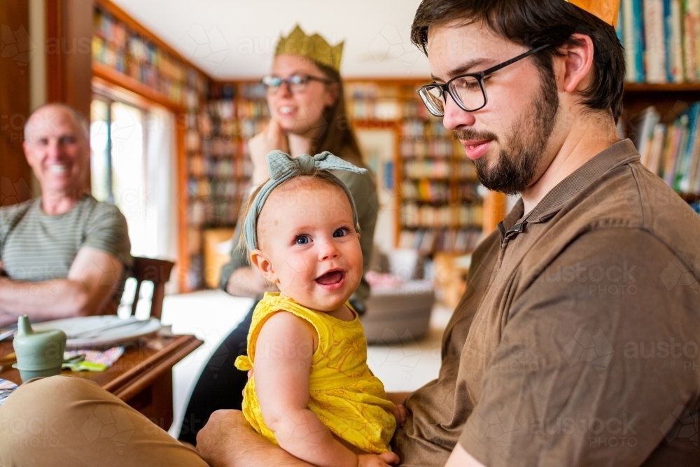 Happy baby with extended family at Christmas lunch celebration - Australian Stock Image