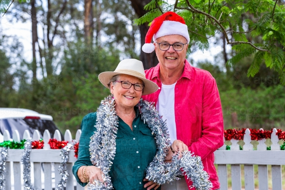 Image of Happy couple in their sixties standing together at Christmas