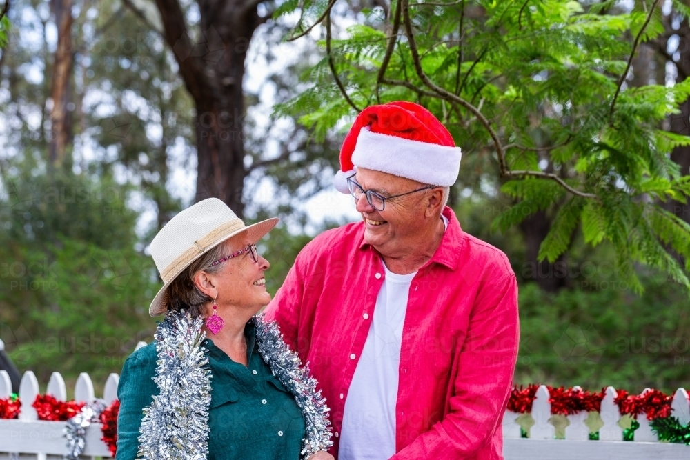 Happy couple in their sixties standing together at Christmas time - Australian Stock Image