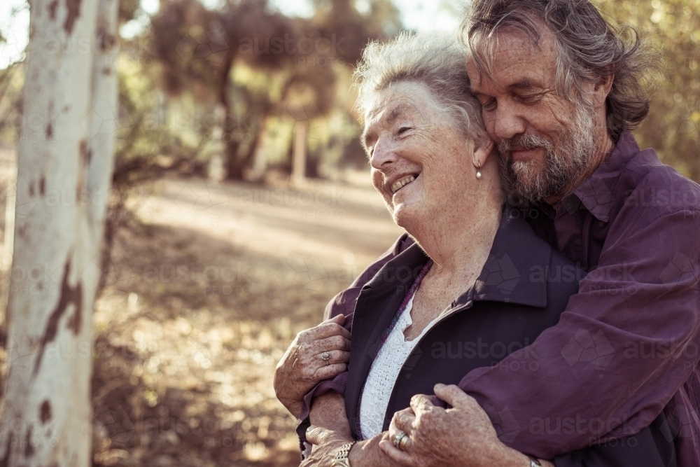 Happy elderly couple hug - Australian Stock Image