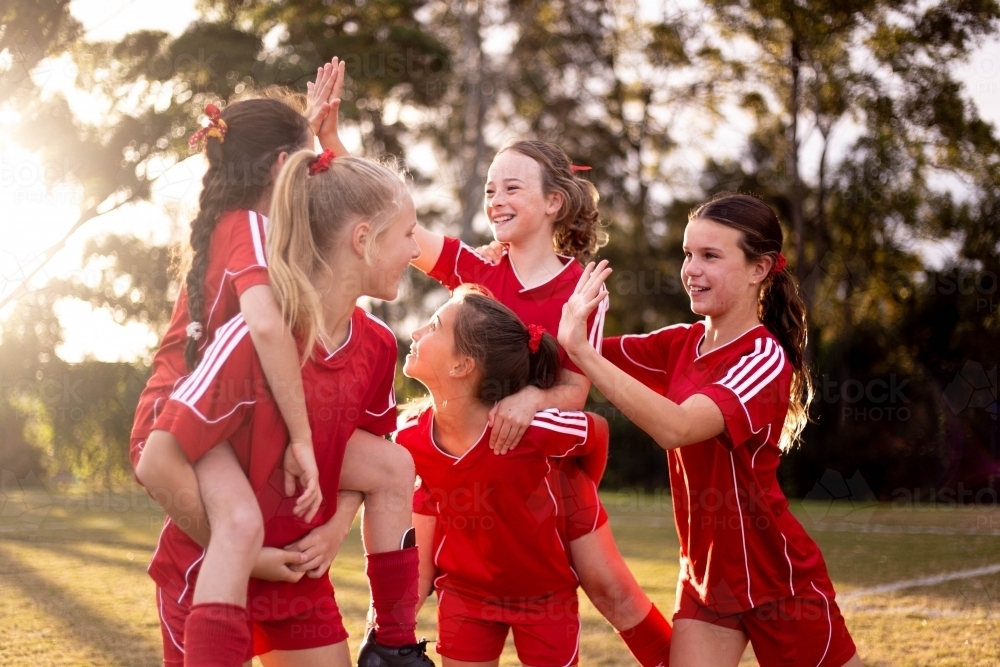 Image of Happy football team of tween girls celebrating together ...