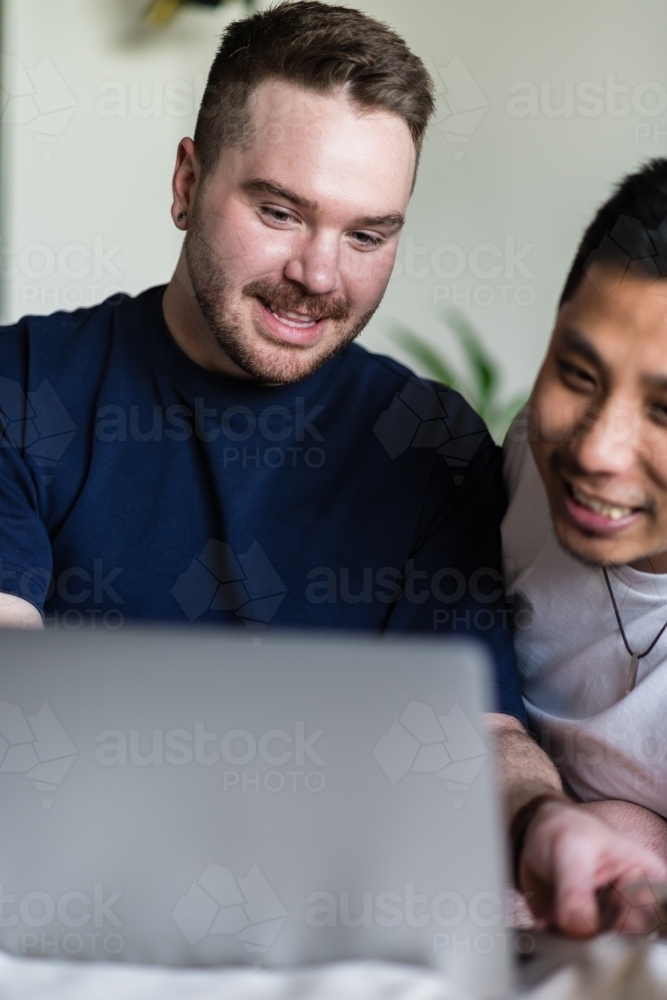 happy gay couple using computer - Australian Stock Image