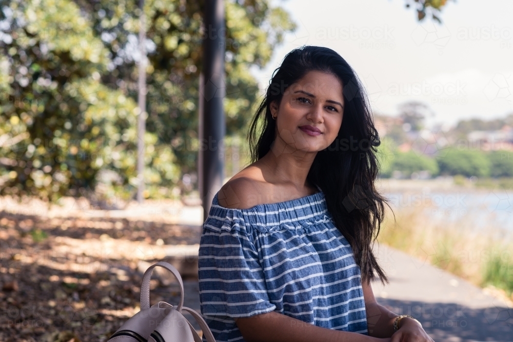 Happy indian woman in a park - Australian Stock Image