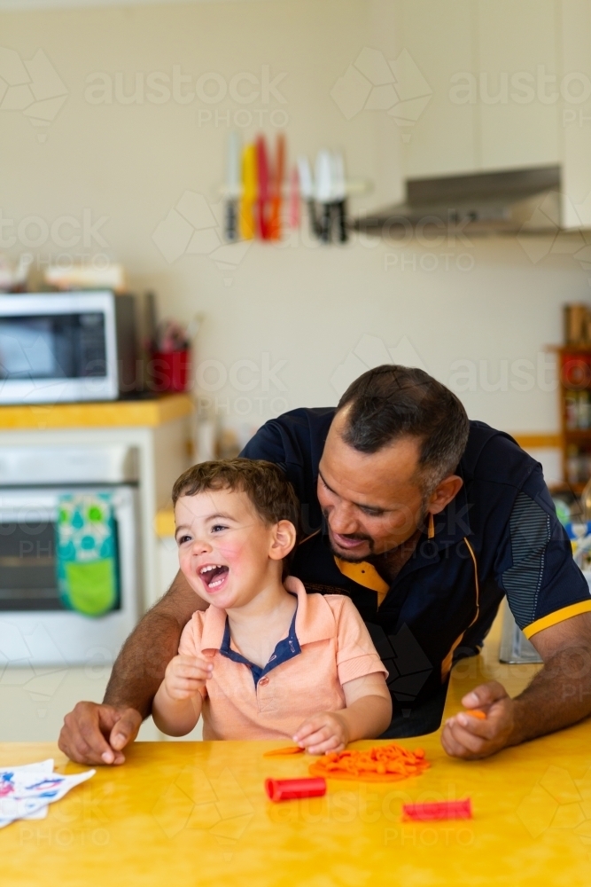 happy little boy with his dad in the kitchen - Australian Stock Image