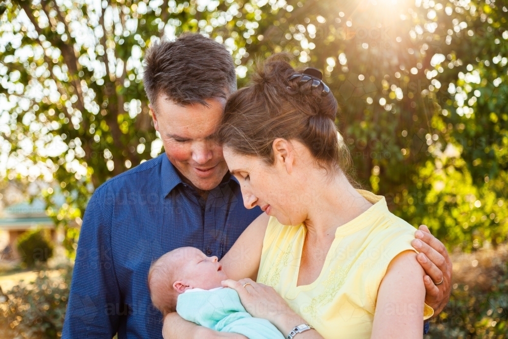 Happy little family with their newborn baby in arms - Australian Stock Image