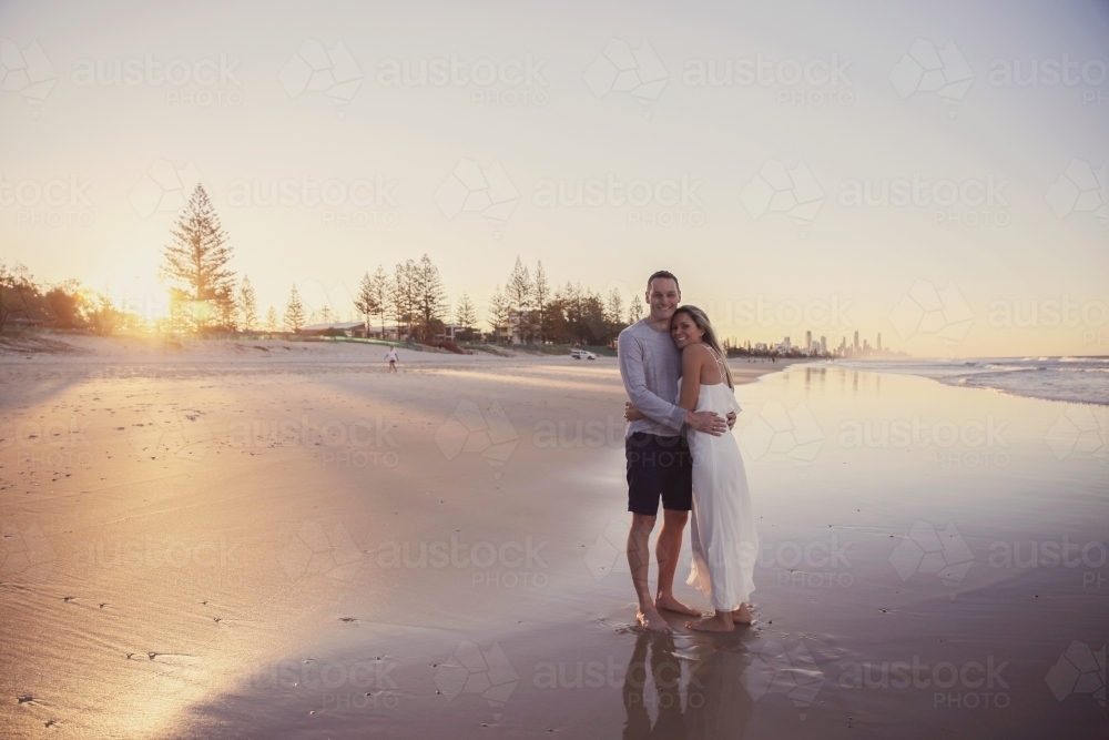 Happy mature couple on the beach at sunset - Australian Stock Image