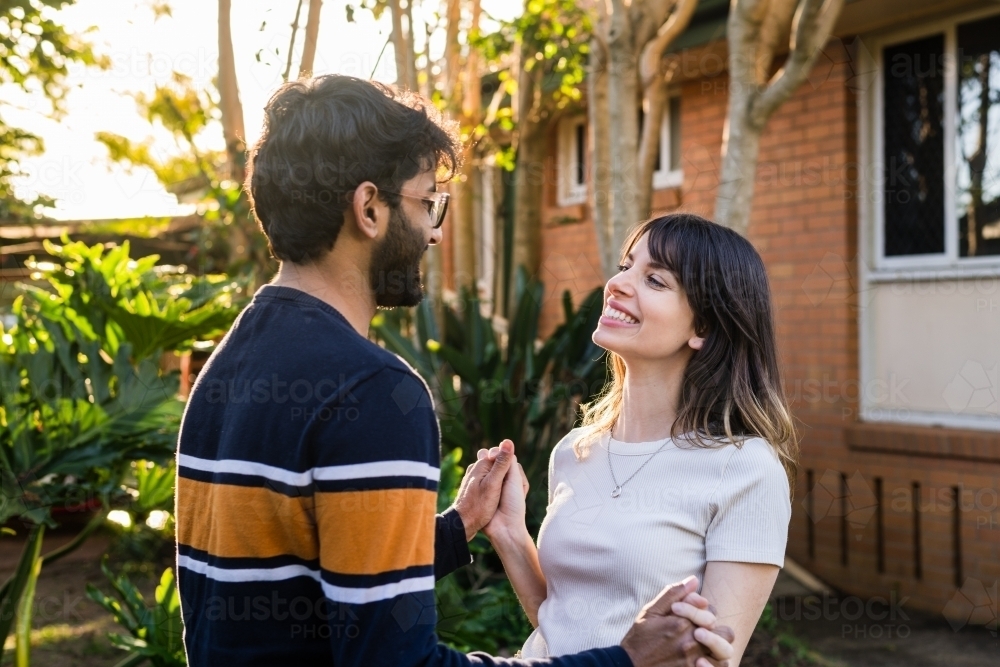 happy mixed race couple holding hands - Australian Stock Image