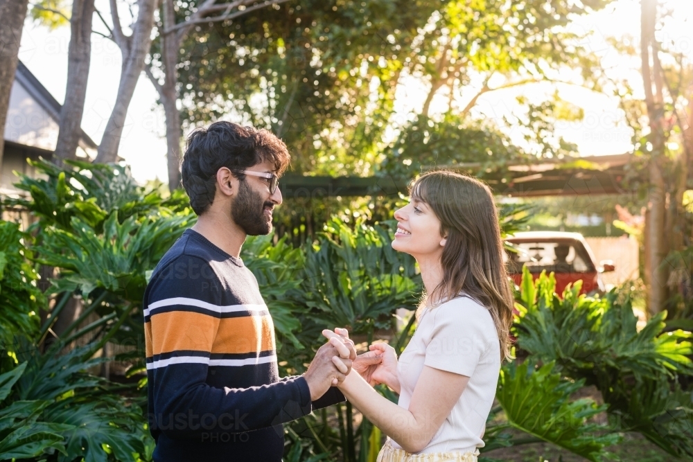 happy mixed race couple holding hands - Australian Stock Image