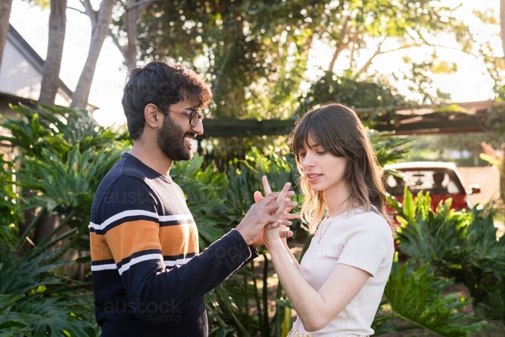 happy mixed race couple holding hands - Australian Stock Image