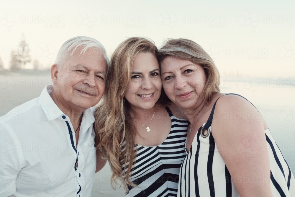 happy multicultural daughter and parents on the beach - Australian Stock Image