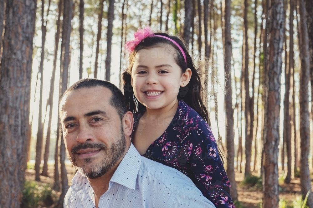 Happy multicultural father and daughter in the wood - Australian Stock Image