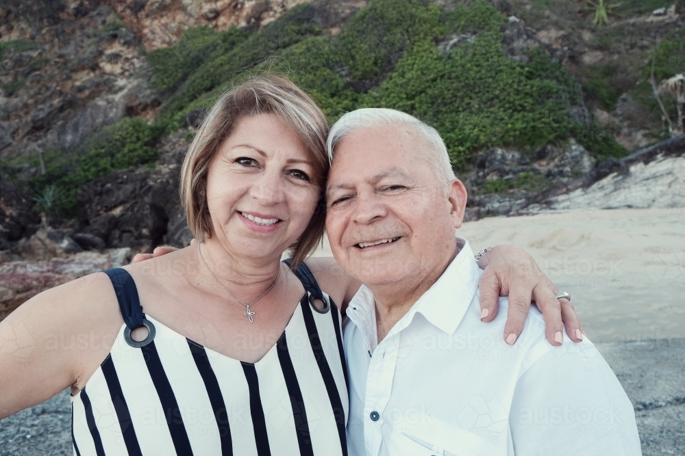 Happy multicultural senior couple on the beach - Australian Stock Image