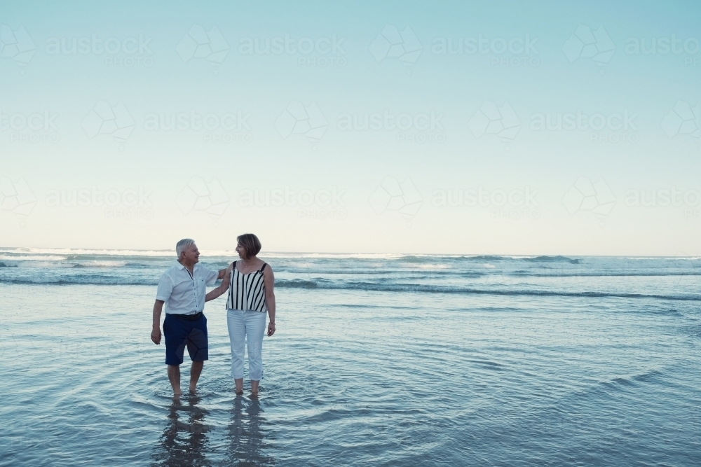 Happy multicultural senior couple on the beach - Australian Stock Image