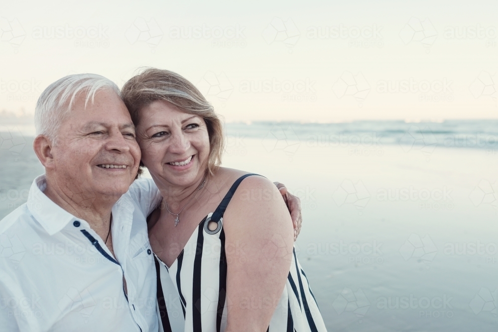 Happy multicultural senior couple on the beach - Australian Stock Image