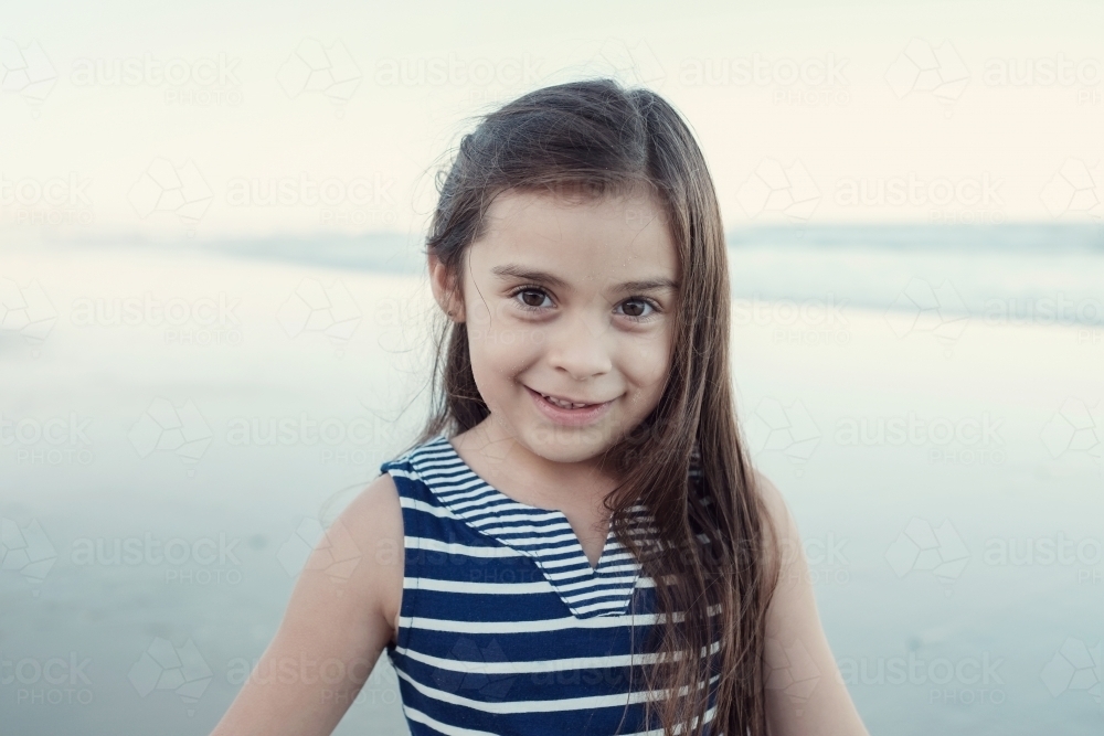 Happy multicultural young little girl on the beach - Australian Stock Image