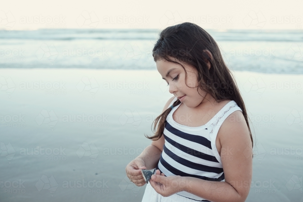 Happy multicultural young little girl on the beach - Australian Stock Image