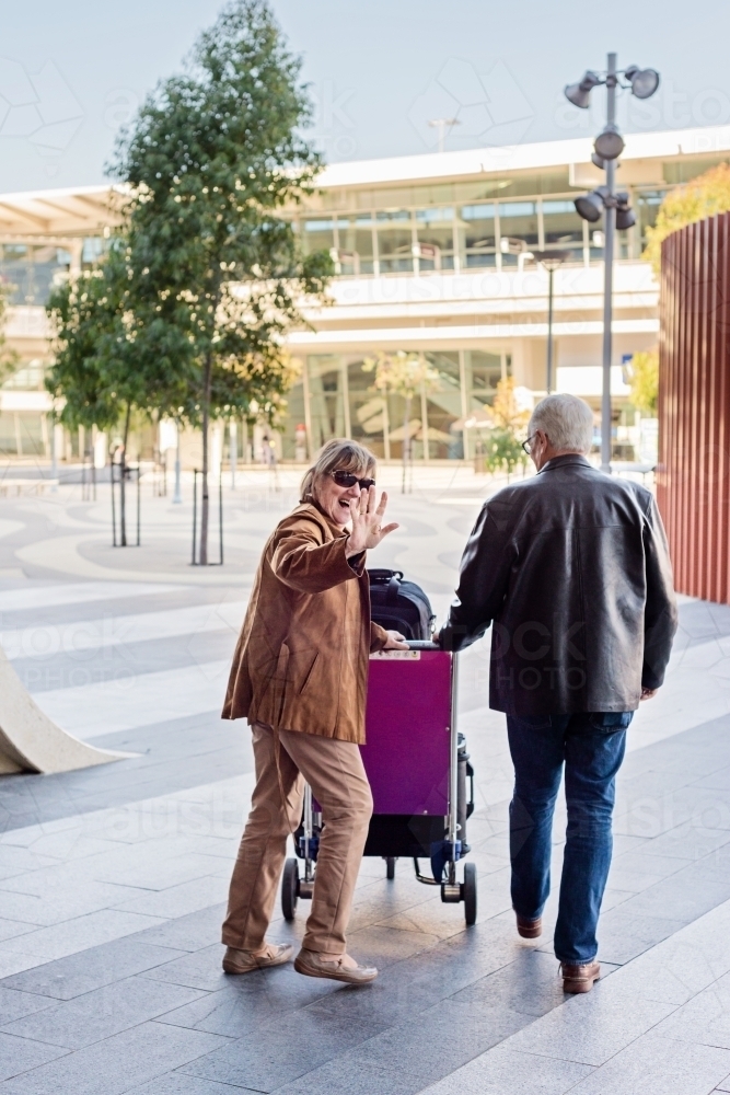 happy senior retired couple heading off at the airport - Australian Stock Image