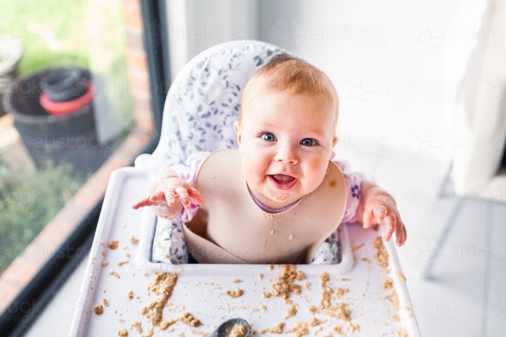 image-of-happy-six-month-old-baby-enjoying-baby-led-weaning-making-mess