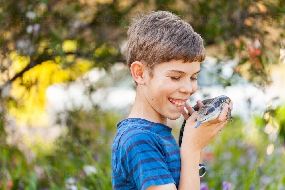 Happy twelve year old Aussie boy with pet blue tongue lizard - Australian Stock Image