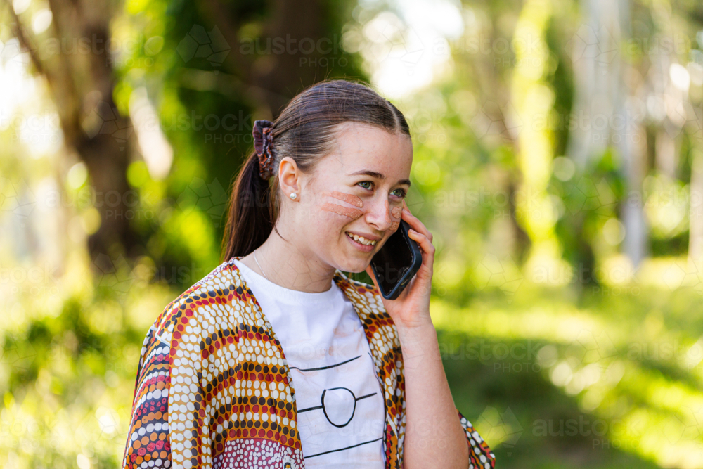 Happy young Aussie person making phone call on mobile device - Australian Stock Image