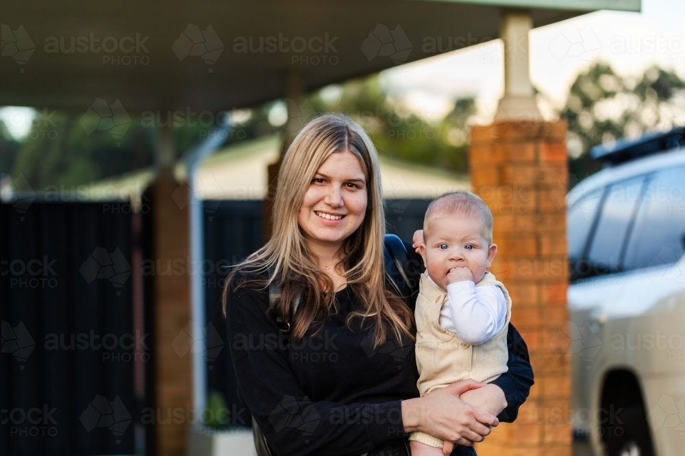 Happy young first nations australian mum with five month old baby boy looking at camera - Australian Stock Image