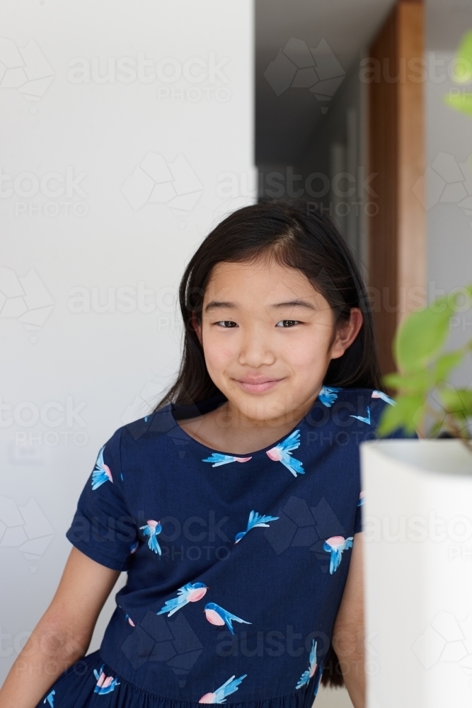 Happy young Japanese girl in kitchen - Australian Stock Image