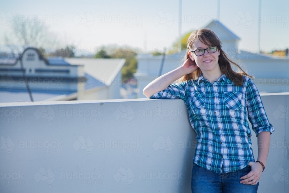 Image of Happy young person leaning on wall and smiling - Austockphoto