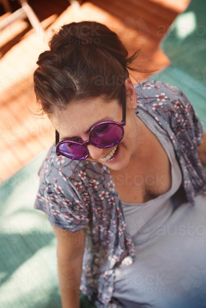 Happy young woman with funny purple sunglasses at a party - Australian Stock Image