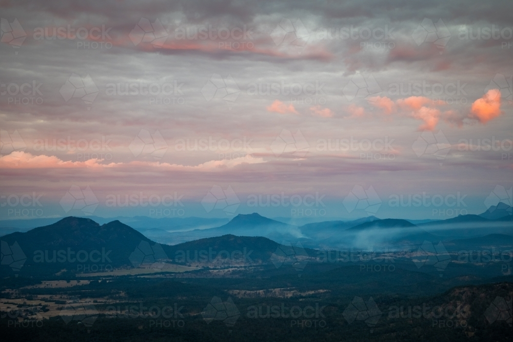 Hazy mountainous landscape under the cloudy sky. - Australian Stock Image