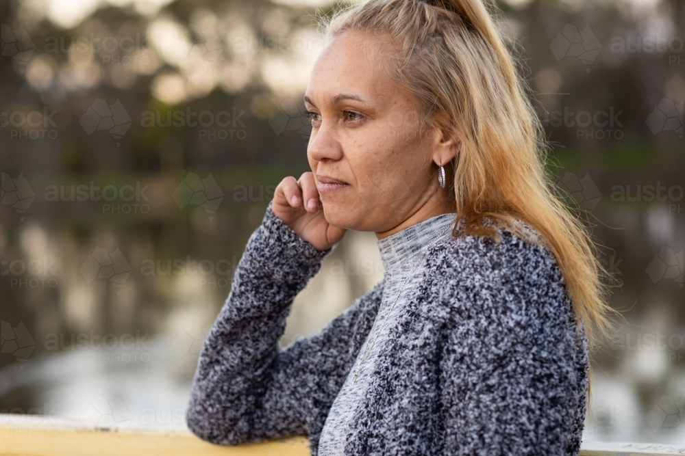 head and shoulders of aboriginal woman with blonde hair side on to camera - Australian Stock Image