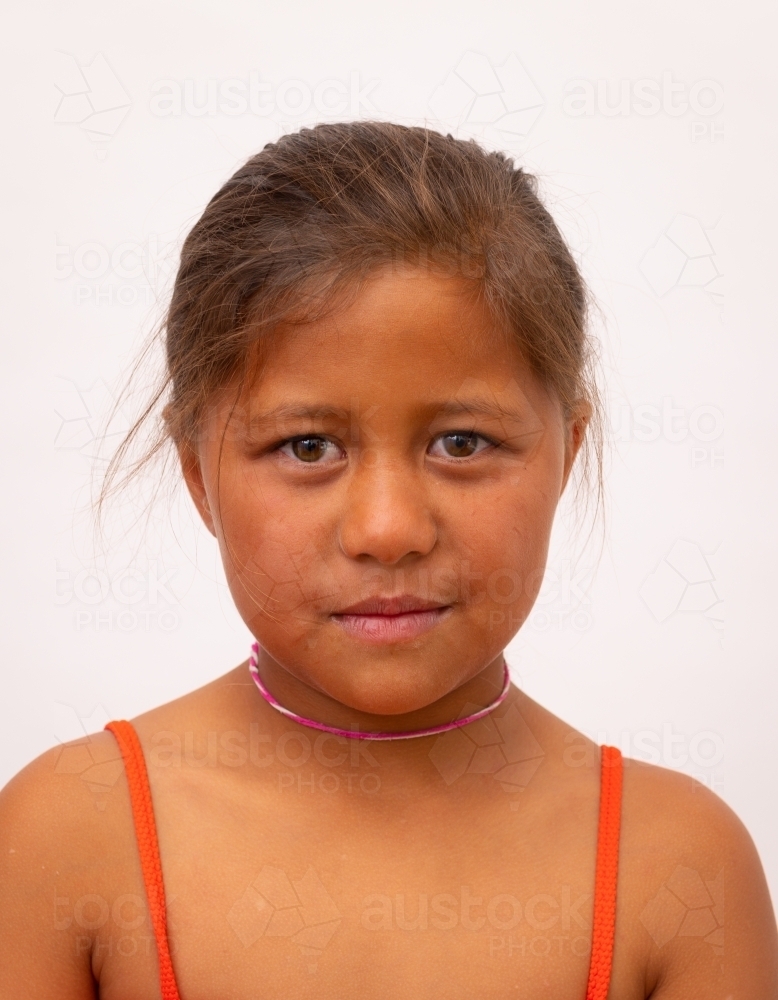 Head and shoulders of Maori child in vertical format against white background - Australian Stock Image