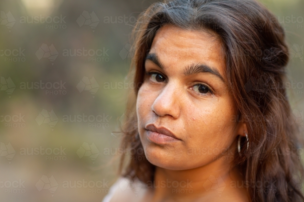 head and shoulders of young woman looking at camera with accusatory look - Australian Stock Image