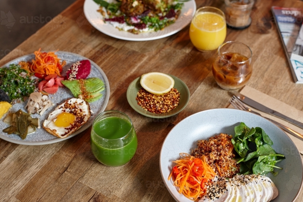 Healthy chicken and salad dish on wooden table in cafe - Australian Stock Image