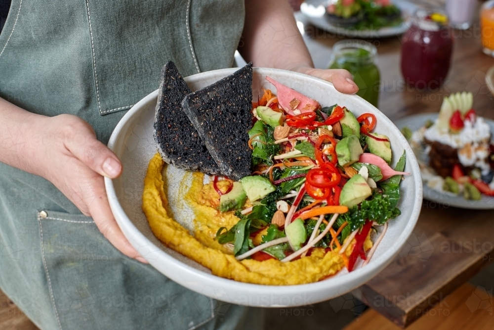 Healthy organic vegan food being held by waiter - Australian Stock Image