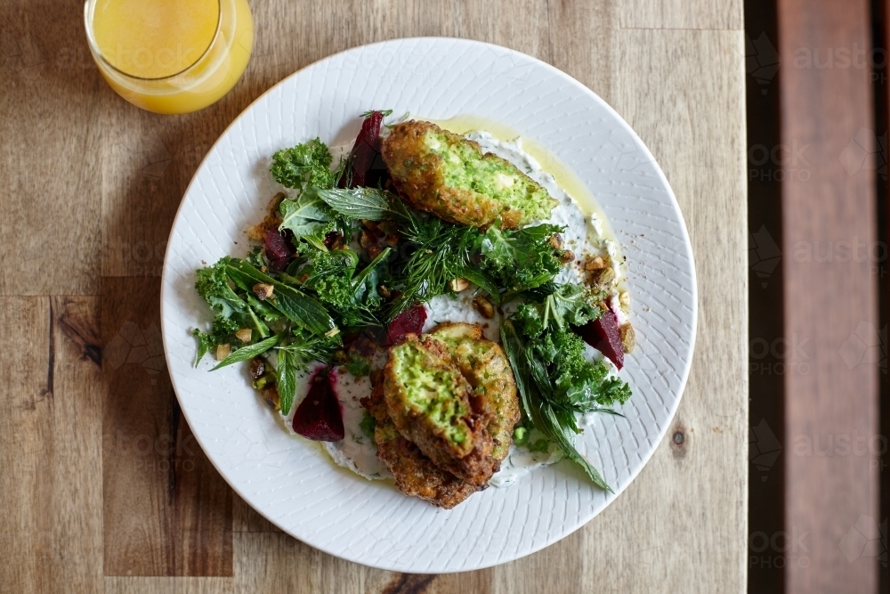 Healthy vegetarian falafel and salad dish on wooden table - Australian Stock Image