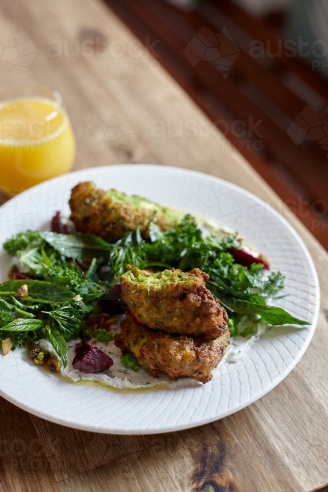 Healthy vegetarian falafel and salad dish on wooden table - Australian Stock Image